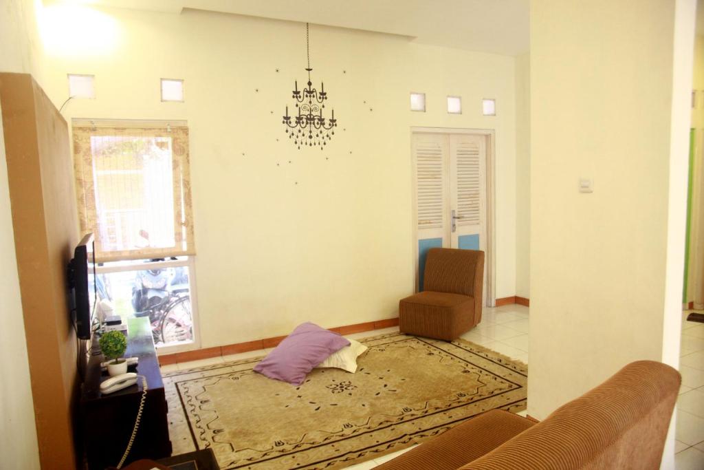 Cipta Guesthouse في يوغياكارتا: غرفة معيشة مع أريكة وكرسي