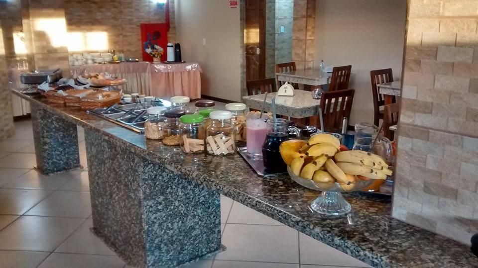 a counter with a bowl of bananas on it at Simar Hotel in Araranguá