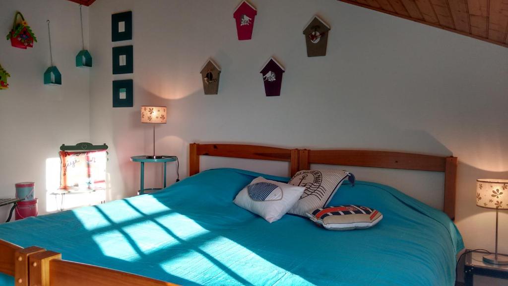 a bedroom with a blue bed with pillows on it at L&#39;Ondine in Pornic