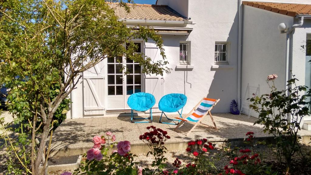 two blue chairs sitting in front of a house at L&#39;Ondine in Pornic