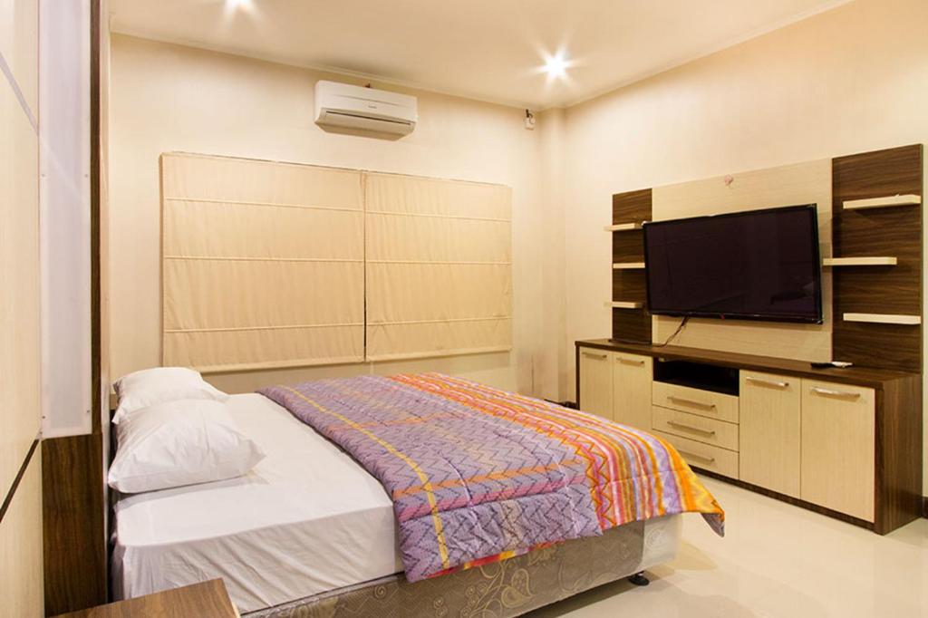 1 dormitorio con 1 cama y TV de pantalla plana en Puri Senggigi Hotel, en Senggigi 