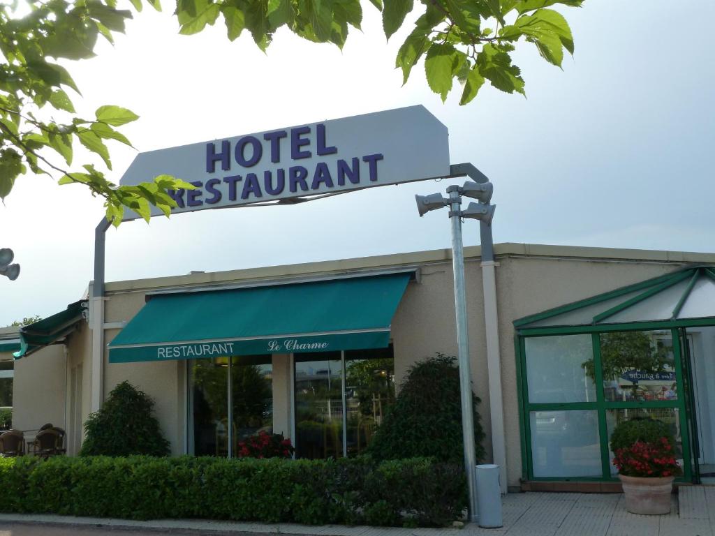 una señal del restaurante del hotel frente a un edificio en Charme Hotel en Beaujolais, en Belleville-sur-Saône