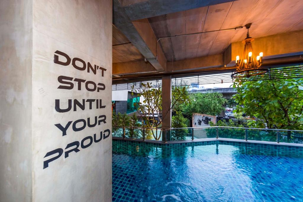 A tiled pool corner framed by a motivational wall message.