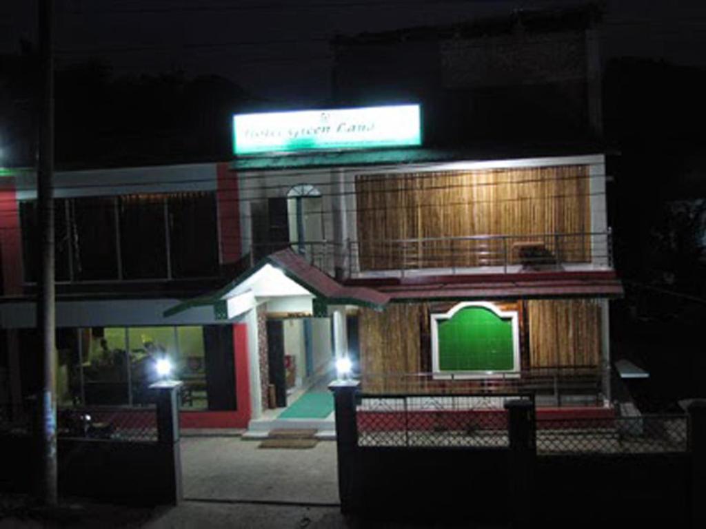 a building with a green sign on it at night at Hotel Green Land in Bāndarban