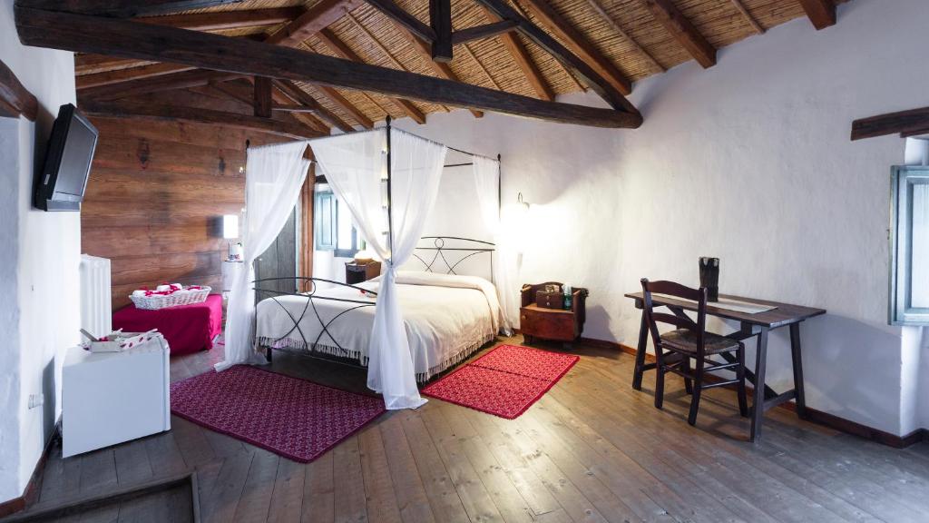 a bedroom with a bed and a table and a desk at B&B Charme Sa Pardina in Orroli
