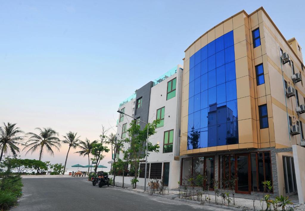 a building with glass windows on the side of a street at Turquoise Residence by UI in Hulhumale