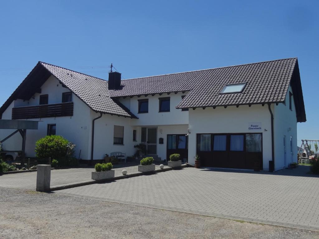 une grande maison blanche avec une allée. dans l'établissement Ferienwohnung Ebersbach, à Guntzbourg