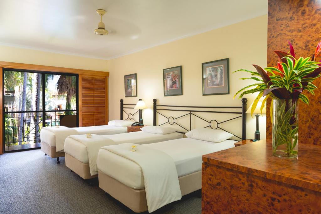 Postel nebo postele na pokoji v ubytování Palm Royale Cairns