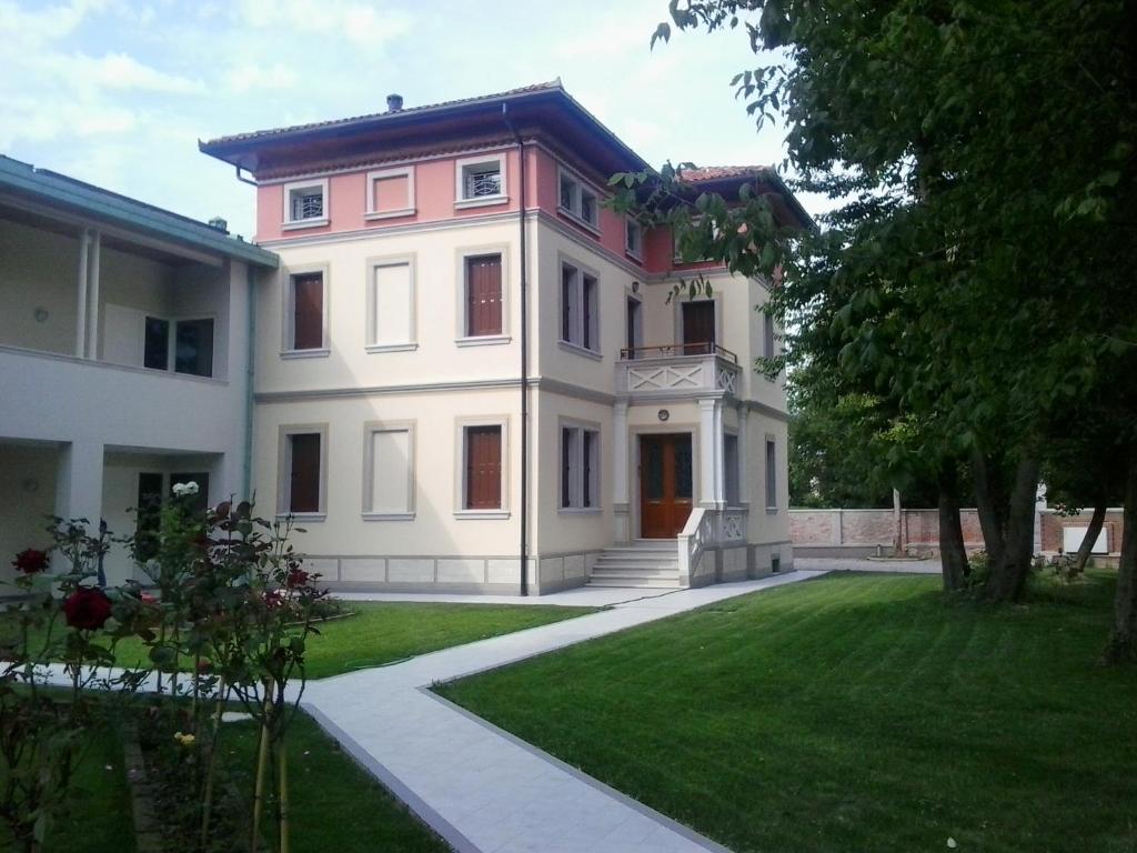 una gran casa blanca con un patio de césped en Villa delle Rose, en Portogruaro