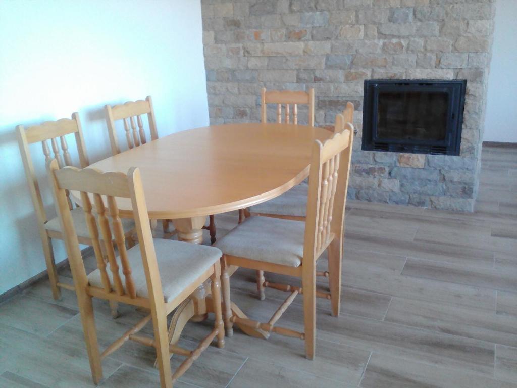 una mesa de madera y sillas en una habitación con chimenea en Casa de Elgo en Balchik