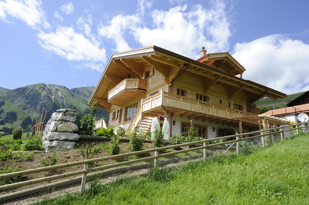 a large wooden house on top of a hill at Chalet Du Mont in Chateau-d'Oex