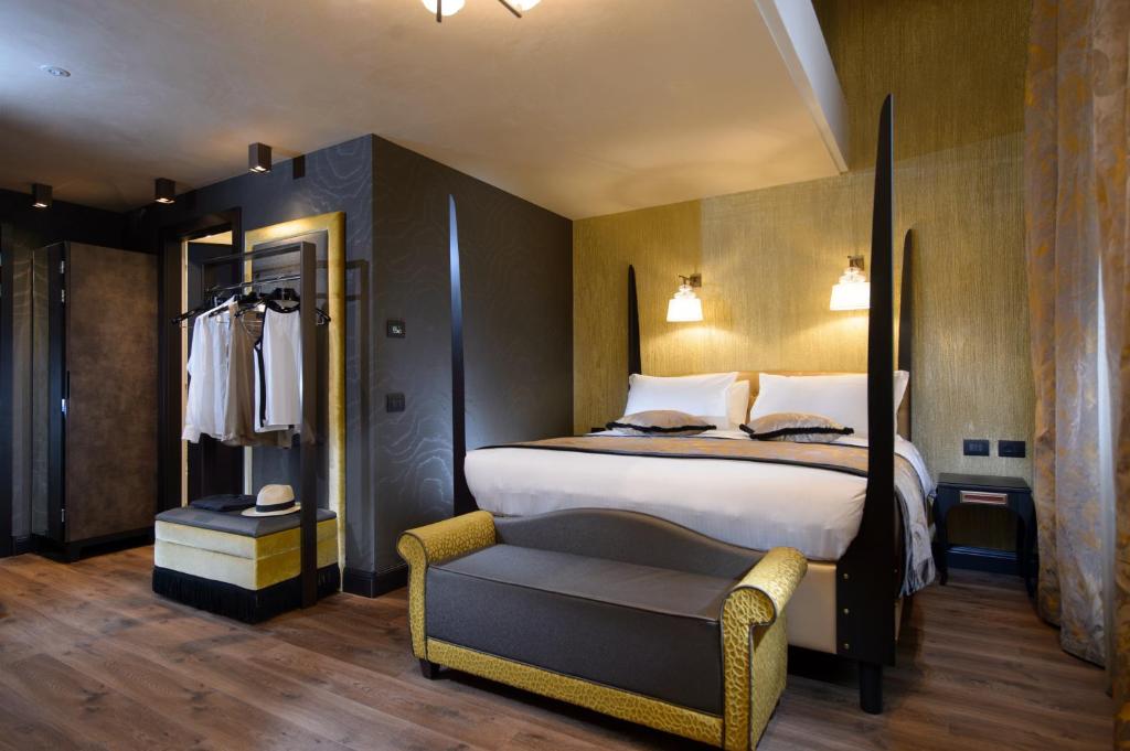 a hotel room with a bed and a chair at Palazzo Veneziano - Venice Collection in Venice