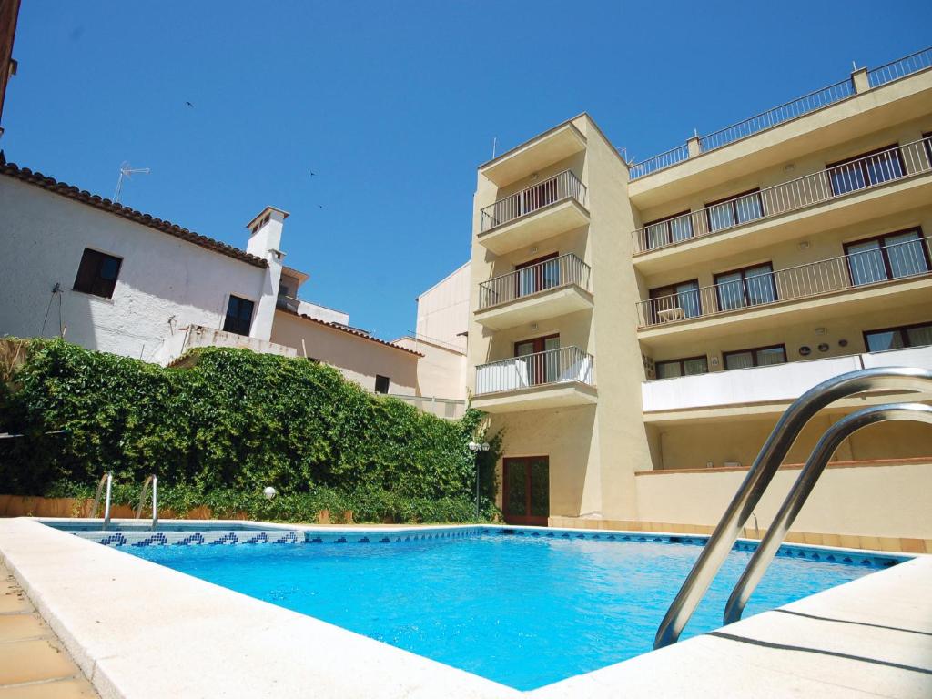 a swimming pool in front of a building at Lets Holidays Palmera III in Tossa de Mar