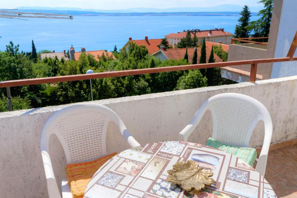 einen Tisch und Stühle auf einem Balkon mit Meerblick in der Unterkunft Apartment Oswald in Crikvenica