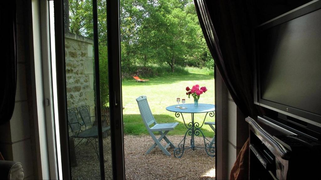 een patio met een tafel en een tafel met bloemen erop bij Le four à pain in Varennes