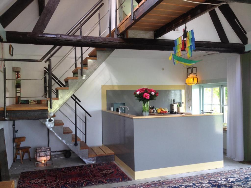 a kitchen with a counter and a staircase in a house at Unique place on the river Waal in Heerewaarden