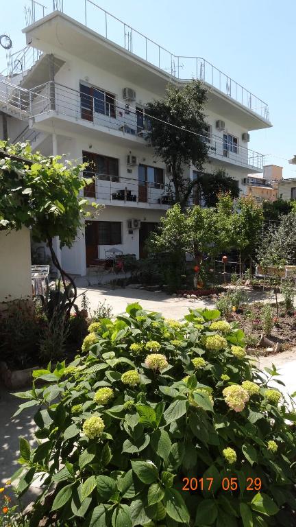 a building with a bunch of flowers in front of it at Nadezhda Guest House in Adler