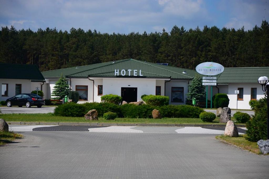 un hotel con un estacionamiento delante de él en Hotel Nevada, en Łagów