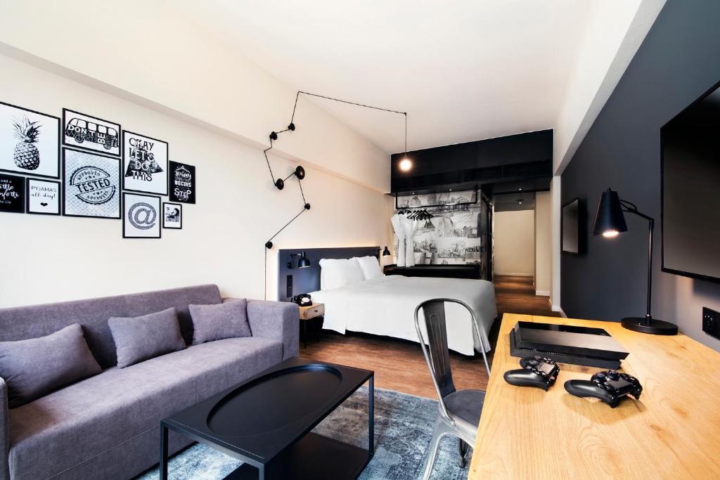 香港にあるPentahotel Hong Kong, Tuen Munのソファとベッドのあるリビングルーム