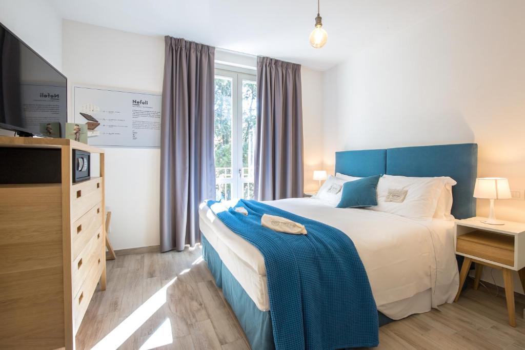 a bedroom with a large bed with a blue headboard at Coco Places Firenze, Centro Storico in Florence