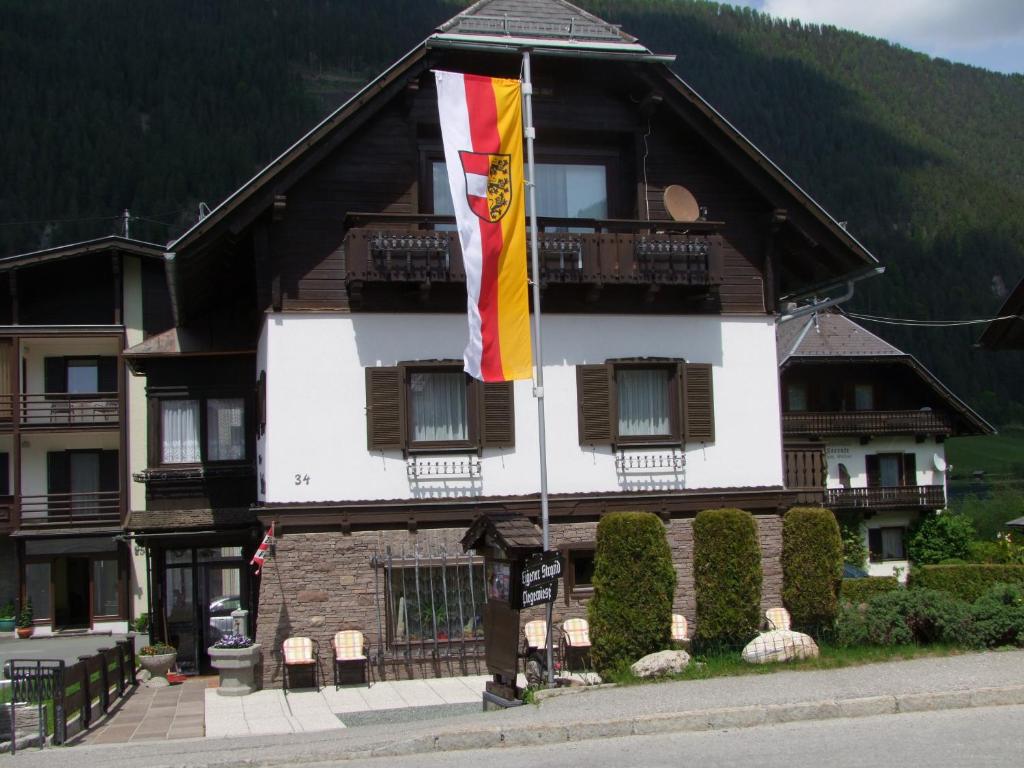 a building with a flag in front of it at Pension Seeheim in Weissensee