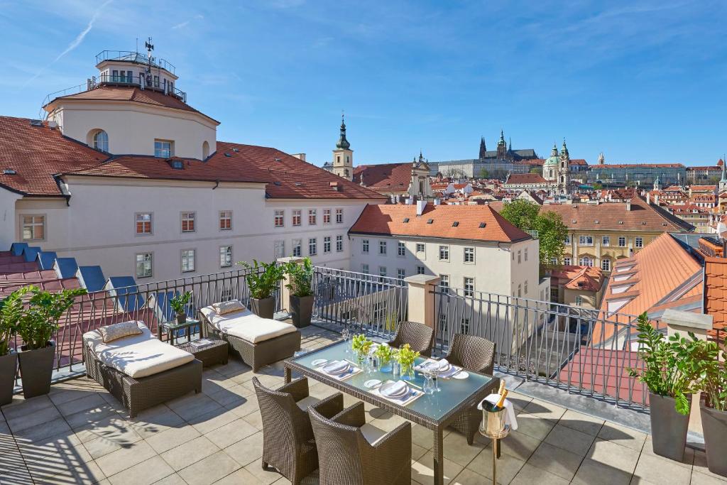 a patio area with a table, chairs, and a balcony at Mandarin Oriental, Prague in Prague