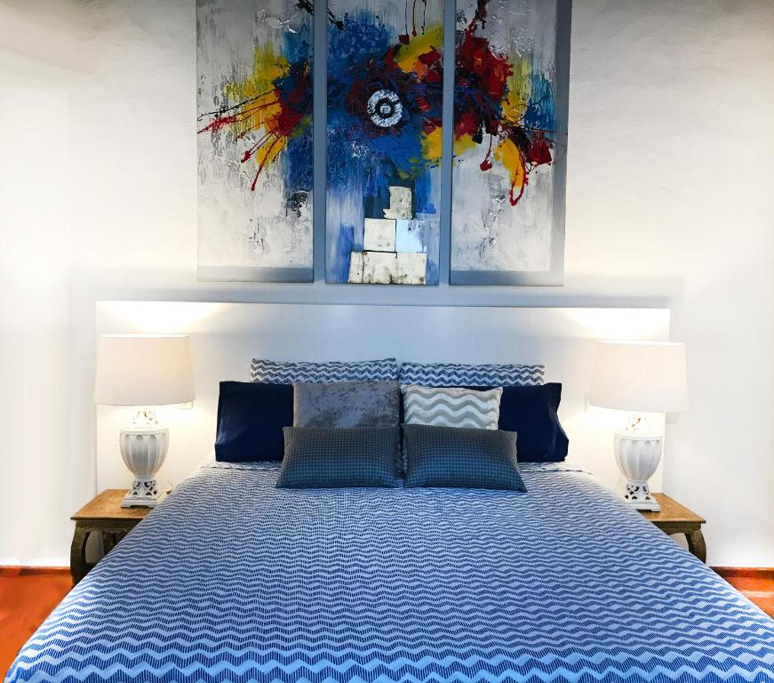 a bedroom with a blue bed with two lamps at Privilege Menorca Apartment in Mahón