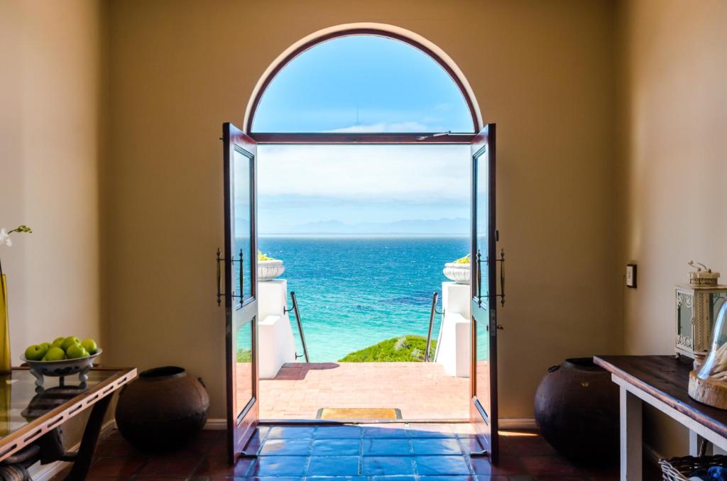 an arched doorway to a room with an ocean view at Whale View Manor & Spa in Simonʼs Town