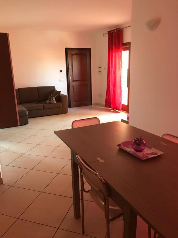 salon ze stołem i kanapą w obiekcie Park 20 Appartamento w mieście Olbia