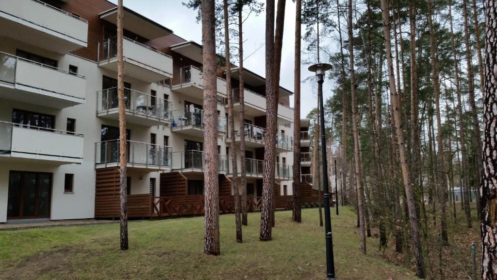 ステグナにあるApartament nr 39 Baltic Parkの手前に木々が植えられたアパートメントビル