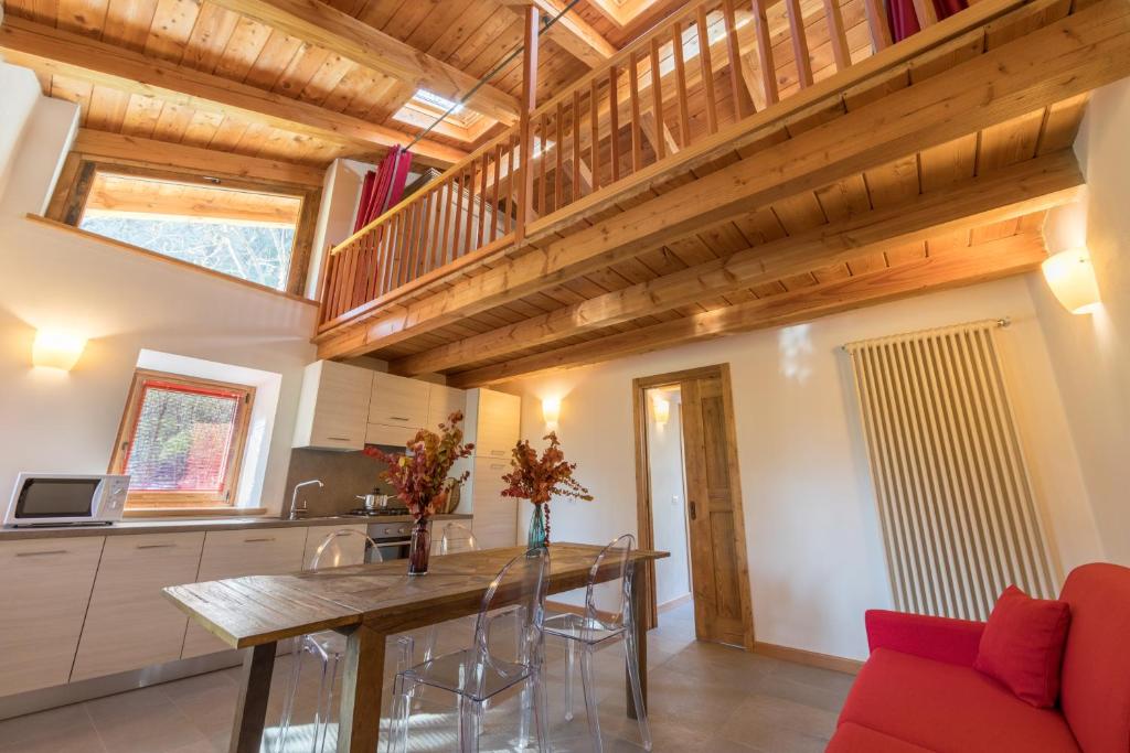 a kitchen with wooden ceilings and a wooden table at L'Atelier du Temps - Le matin clair in Aosta