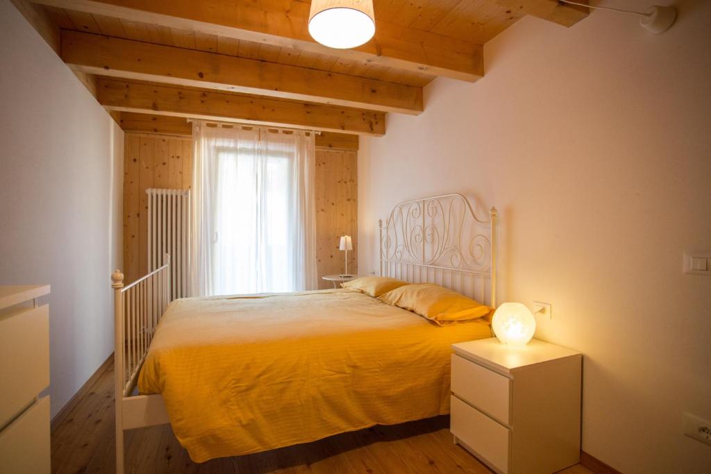 ラヴァローネにあるCasa Prombisのベッドルーム1室(黄色のベッドカバー付)、窓が備わります。