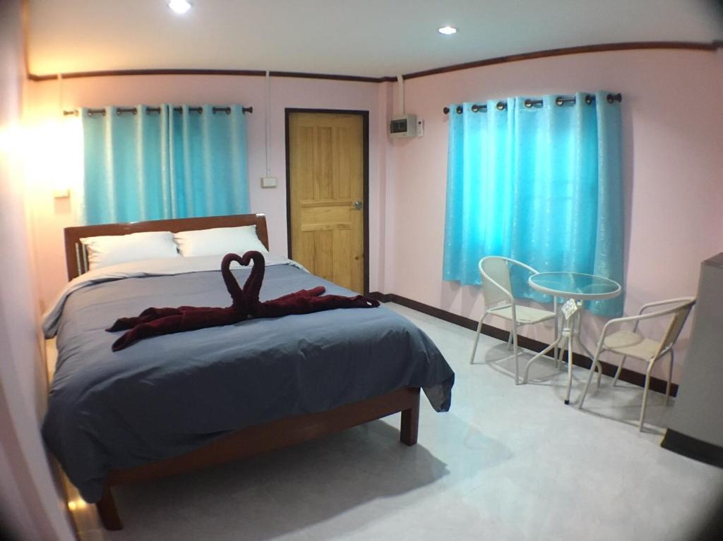 a bedroom with a bed with a ribbon on it at Smile Resort in Ban Phai Cham Sin