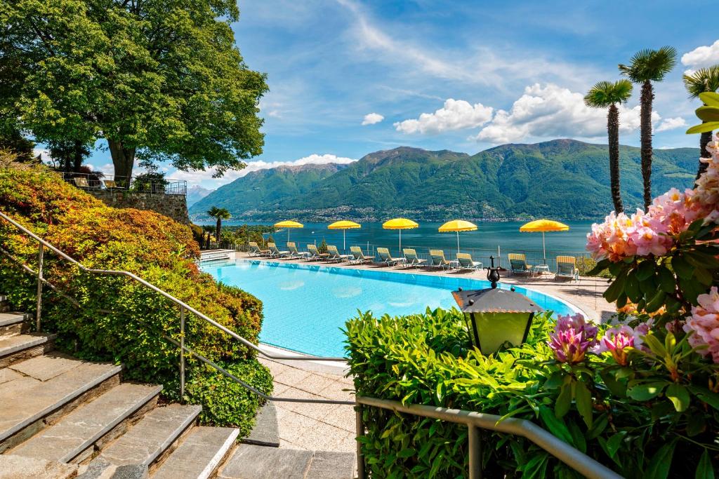 a swimming pool with chairs and umbrellas at Casa Berno Swiss Quality Hotel in Ascona