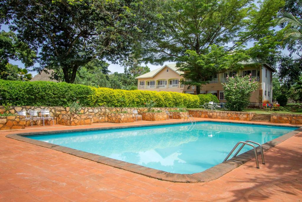 a swimming pool in front of a house at Jinja Safari Hotel in Jinja