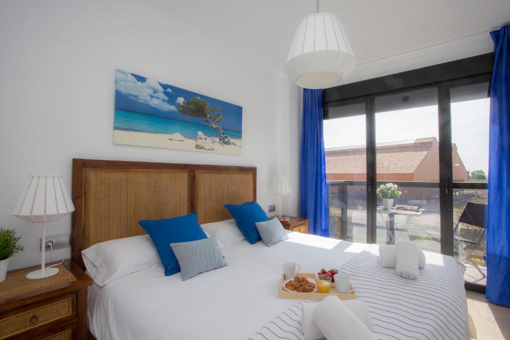 a bedroom with a large white bed with blue pillows at SingularStays Artes in Valencia