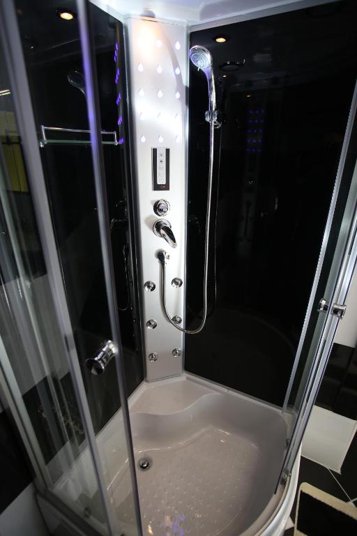 W łazience znajduje się prysznic ze szklanymi drzwiami. w obiekcie Centrum Lux Apartman w mieście Kaposvár