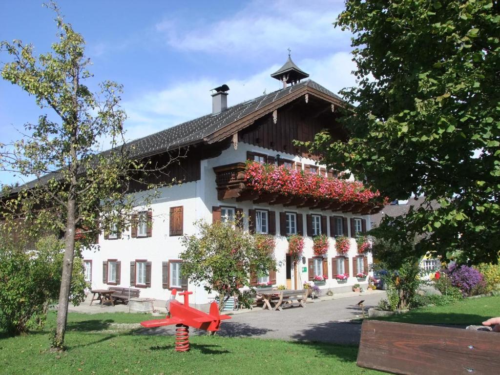 a large white building with flowers on the windows at Ferienhof Hinterstrasser in Mondsee