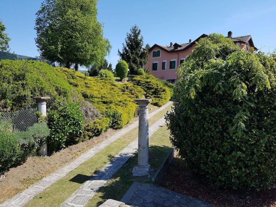 einen Garten mit einer Statue vor einem Haus in der Unterkunft Villa Le Vignole in Ameno