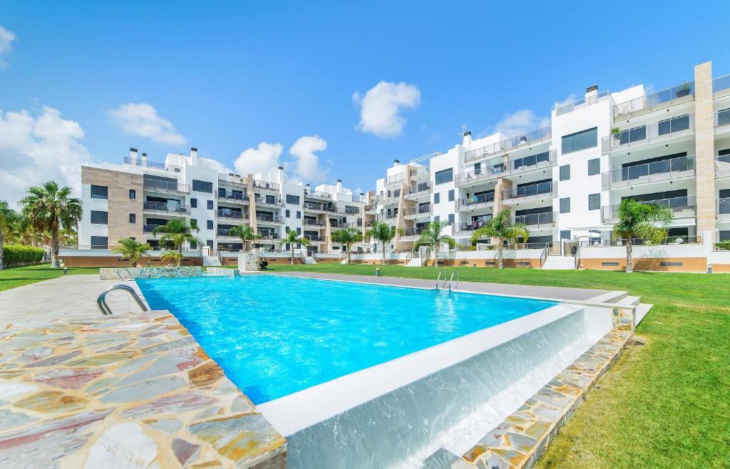 an apartment with a swimming pool in front of a building at Bennecke Niagara in Cabo Roig