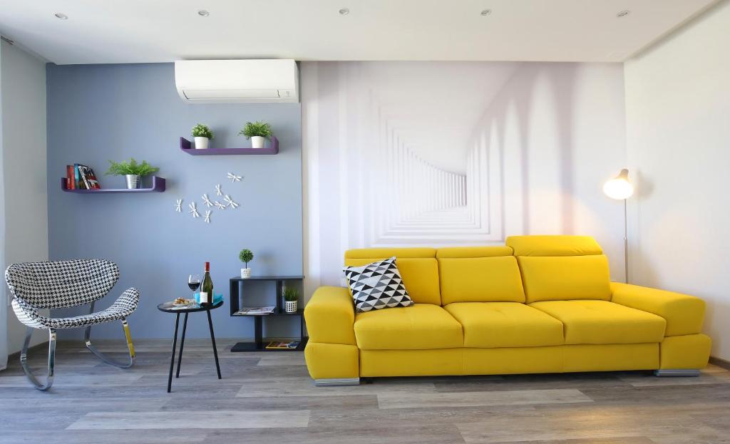 a living room with a yellow couch and a table at Apartment Zadractive - perfect view but no elevator in Zadar