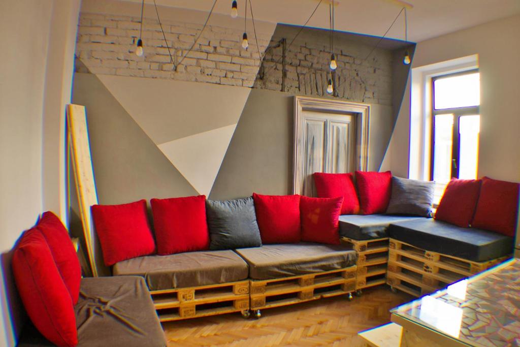 uma sala de estar com sofás e almofadas vermelhas em Cloud 9 Living em Bucareste