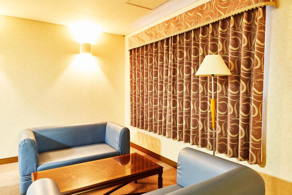 a waiting room with a table and chairs and a lamp at Nasushiobara Station Hotel in Nasushiobara