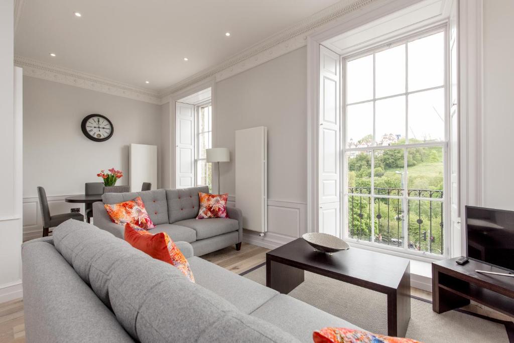 a living room with a couch and a tv at Destiny Scotland - Chisholm Hunter Suites in Edinburgh