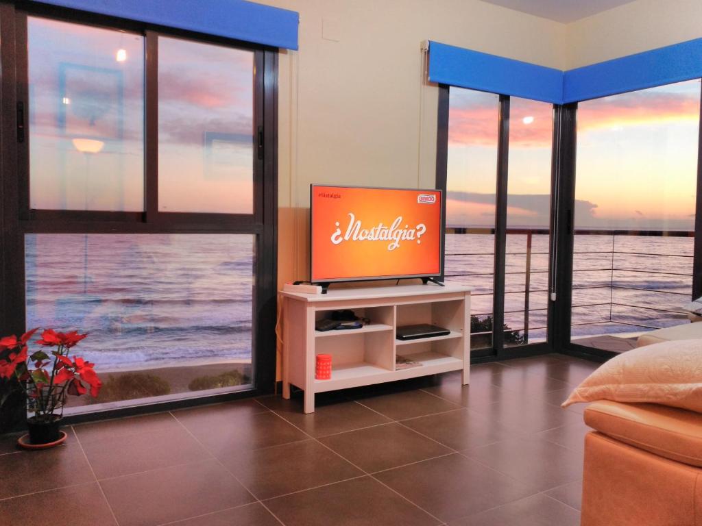 a television in a living room with a view of the ocean at Camarote in El Morche