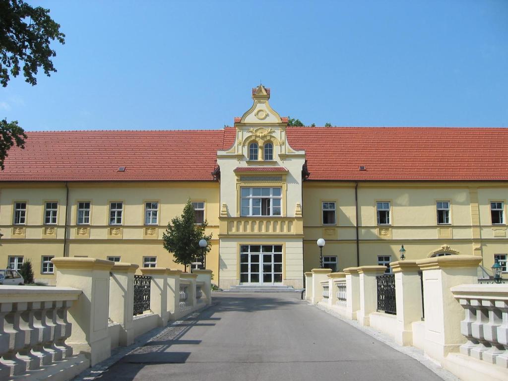 un grand bâtiment jaune avec un toit rouge dans l'établissement Junges Hotel Tulln, à Tulln