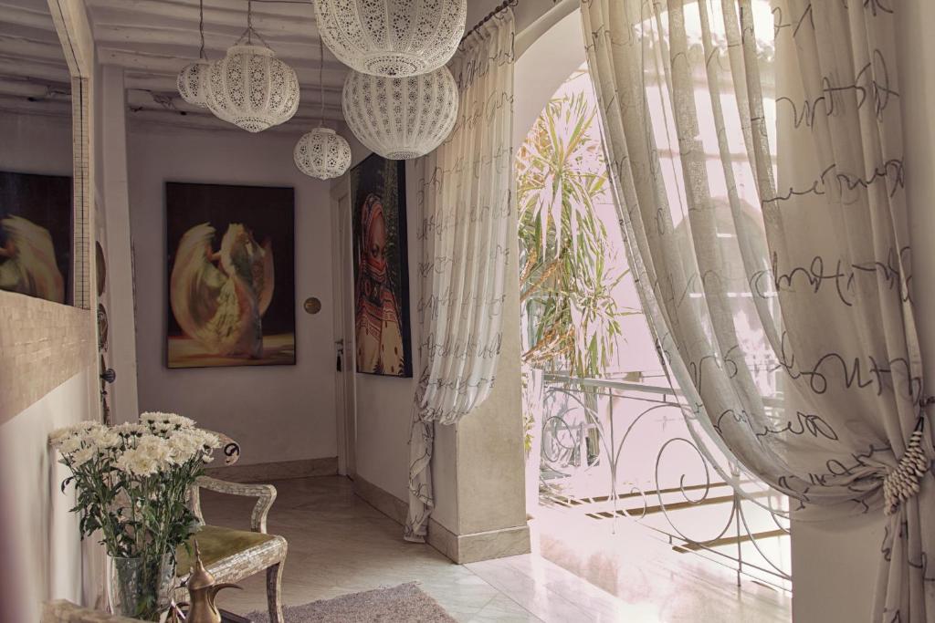 a room with curtains and a chair and a window at Riad Infinity Sea in Marrakech