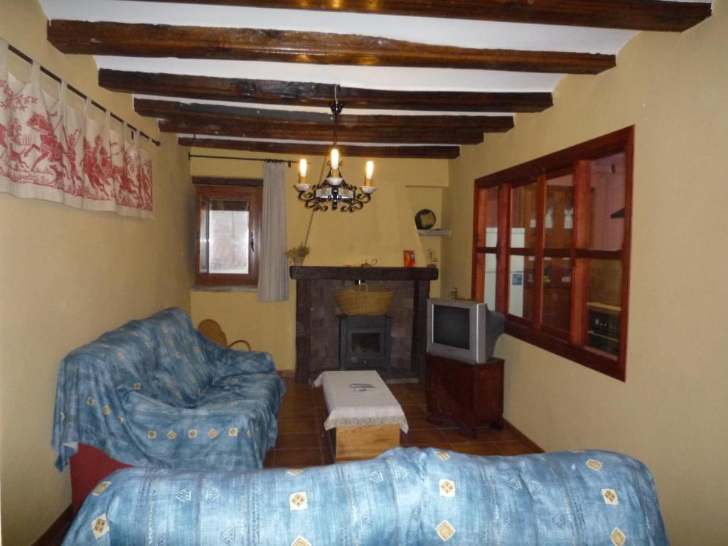 a living room with a couch and a fireplace at Casa rural L'Hospital in Vistabella del Maestrazgo
