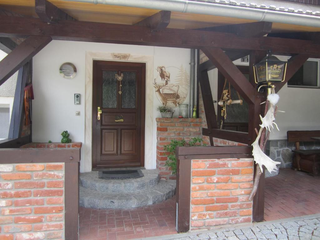 uma casa com uma porta de madeira e uma parede de tijolos em Landsauna - Pension em Zittau