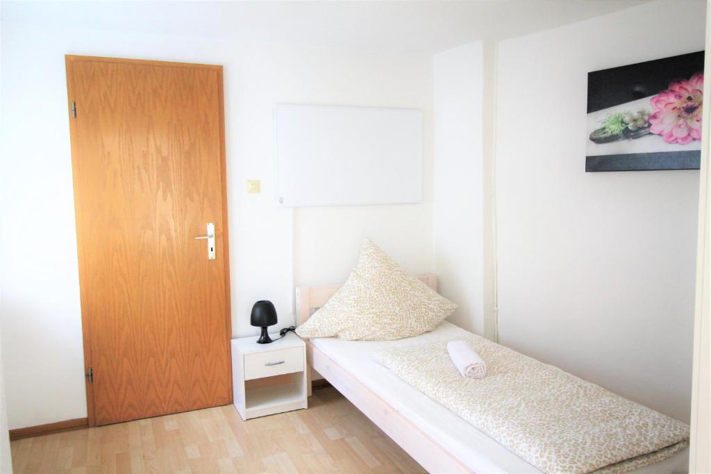a small bedroom with a bed and a wooden door at Work & Stay in Zuelpich in Zülpich